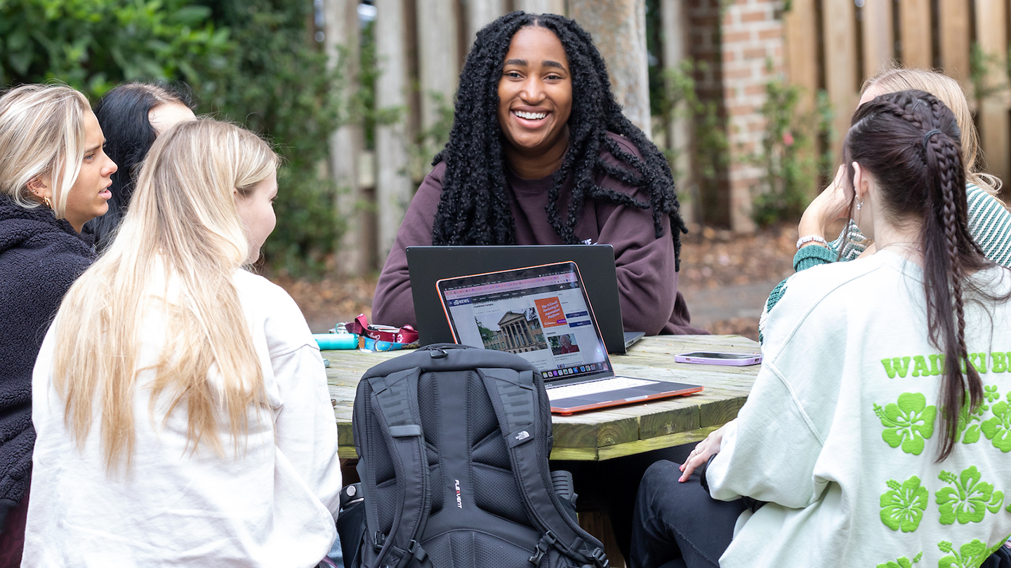 Students sitting at a table on the College of Charleston campus.