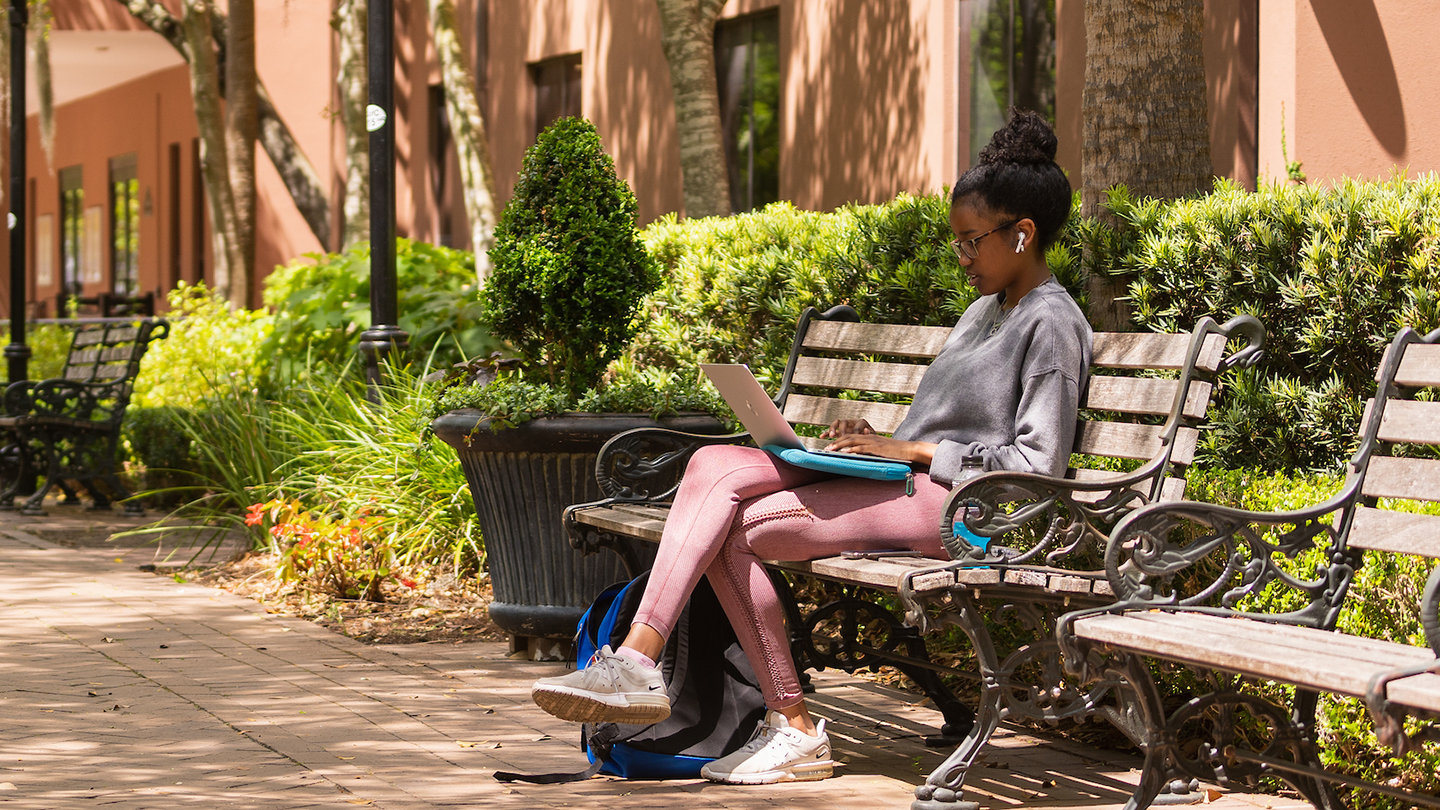 A student using her laptop on the College of Charleston campus.