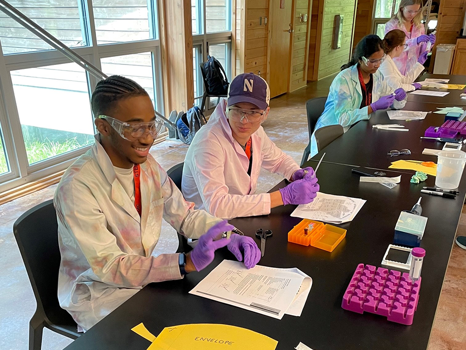 Students sitting at a table holding a test tube and learning about science.