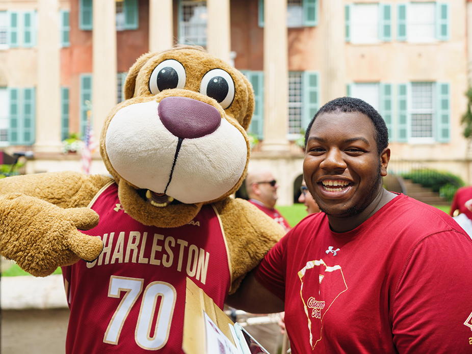 Clyde the Cougar, College of Charleston mascot, and a student in front of Randolph Hall.