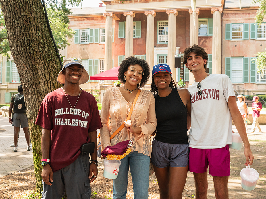 Four students smiling in Cistern Yard. 