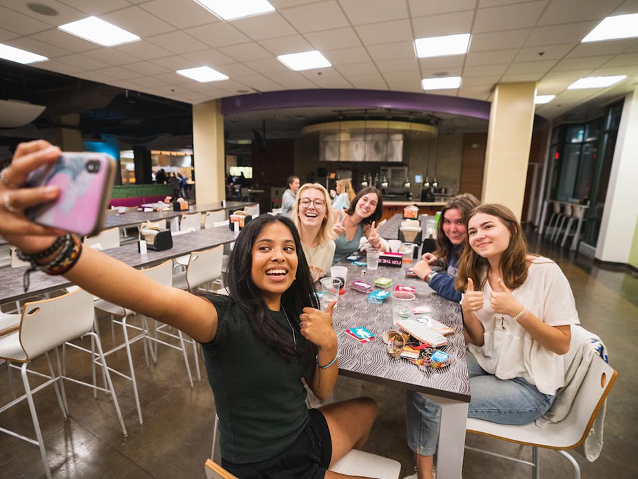 College of Charleston students take a selfie while sitting at a table in Liberty St. Fresh Food Company. 
