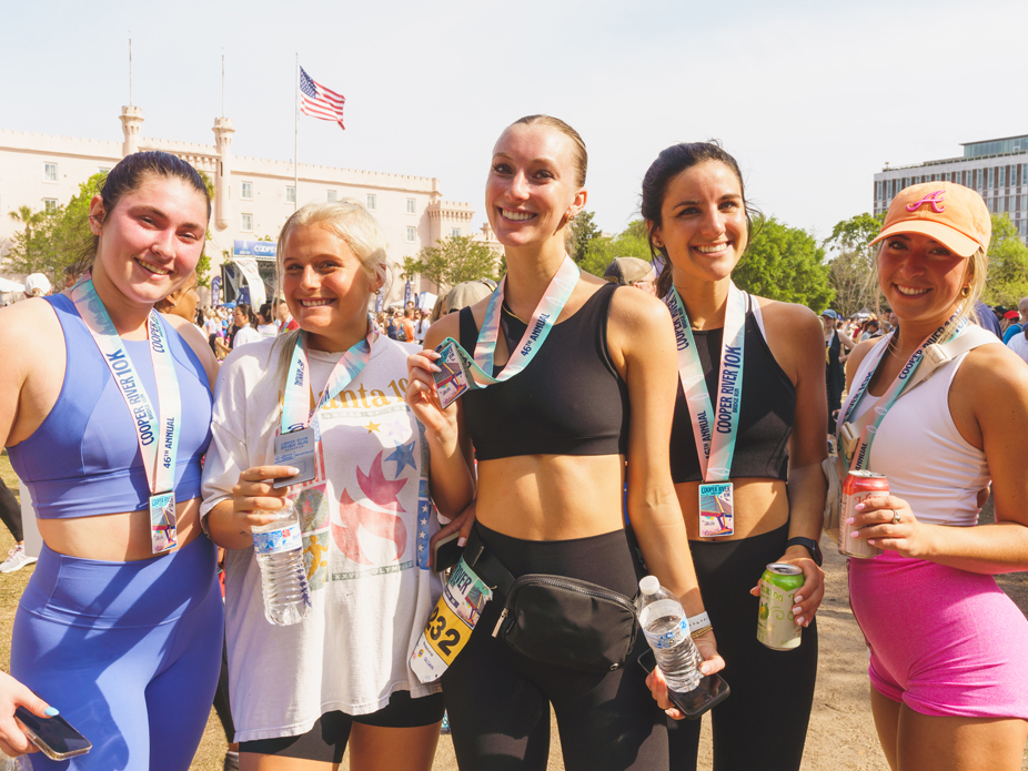 Five College of Charleston women show off their medals after completing the 10k Cooper River Bridge Run.
