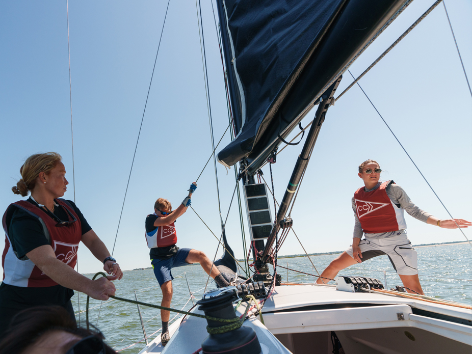 Three College of Charleston students hoist the sail on one of the College's 36 sailing vessels