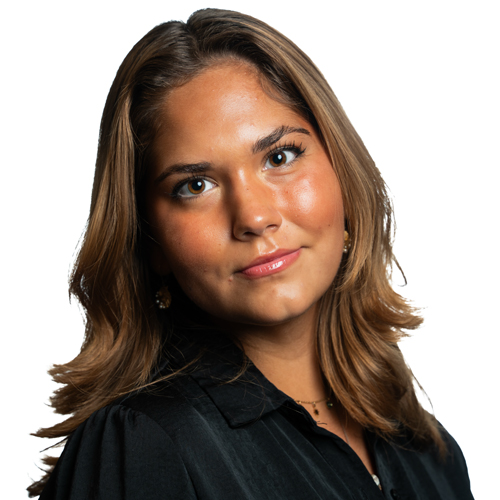 Portrait of Blanka Prikasky, a young woman with long, wavy hair and a confident expression, wearing a black shirt.