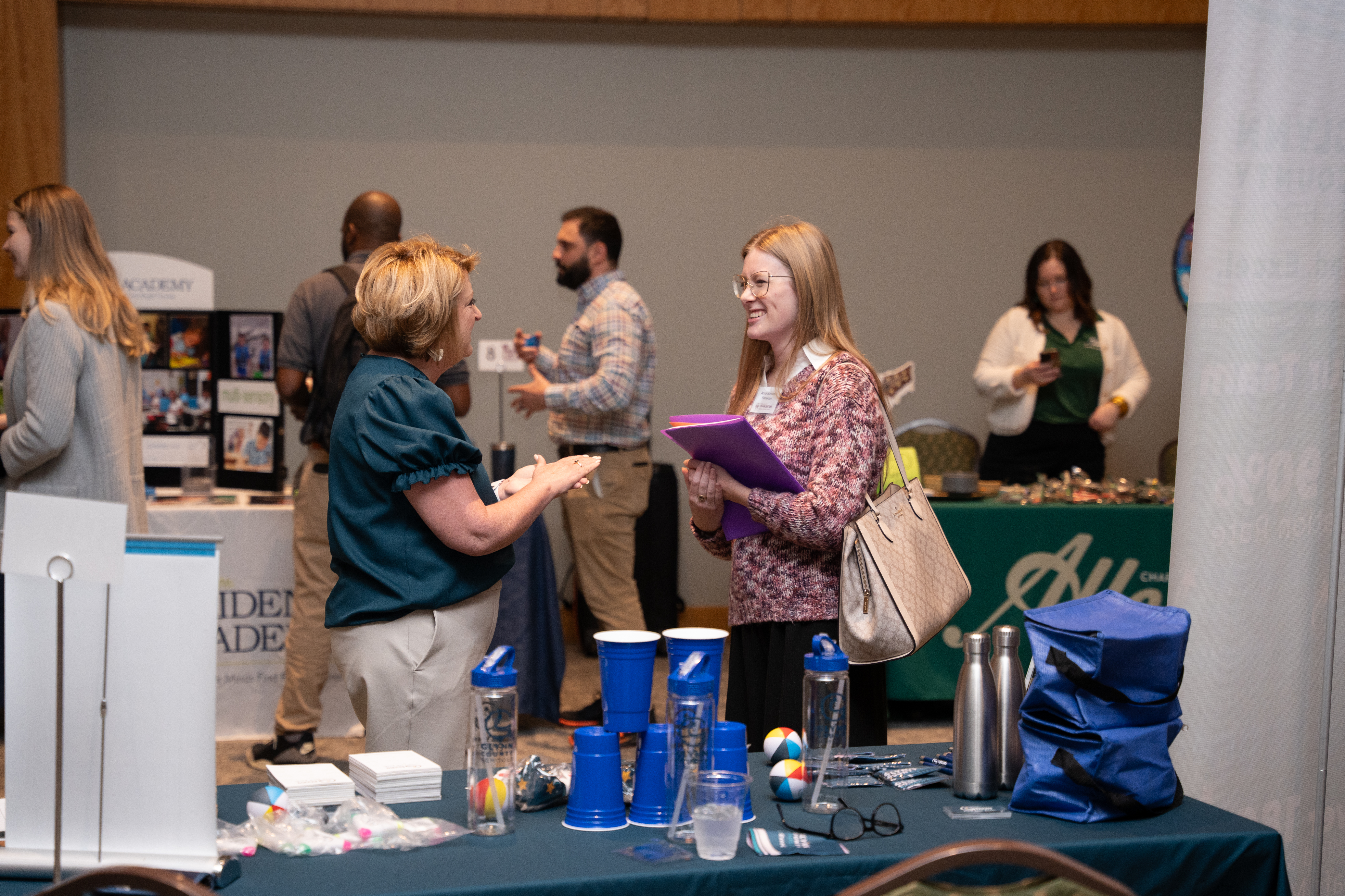 Recruiter and potential employee talking at recruitment event.