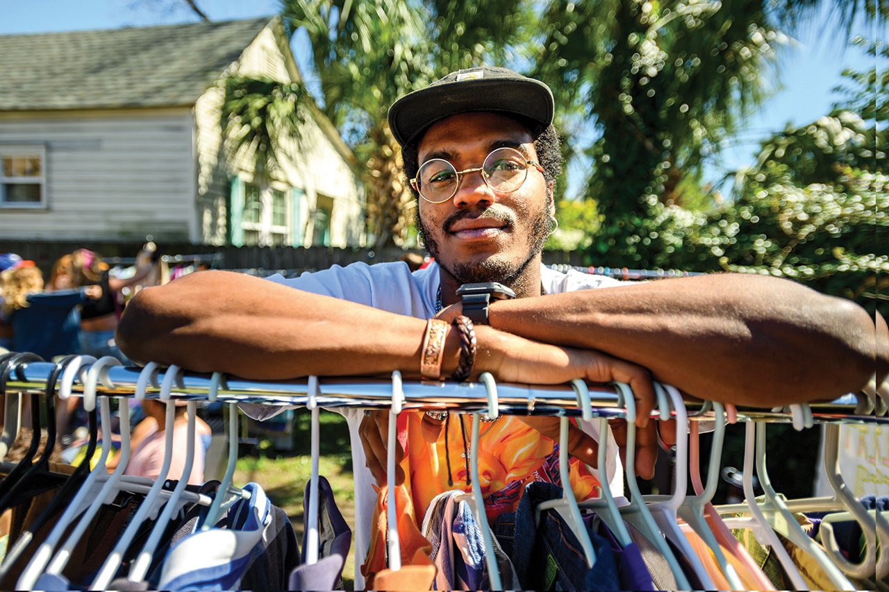 Student Brandon Alston standing behind a clothes rack.