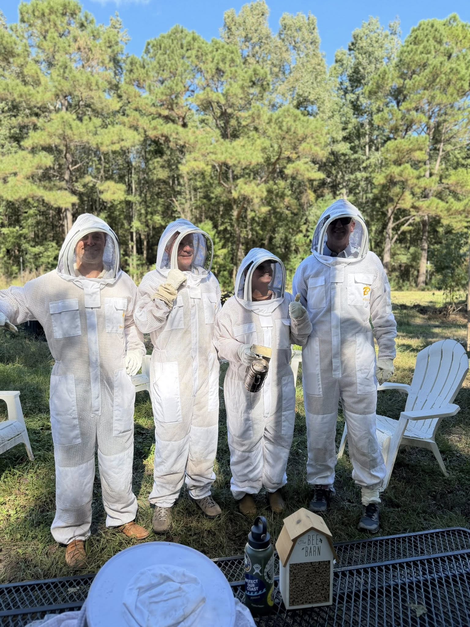Four CofC board members is beekeeper equipment prepare for a first-hand beekeeping experience. 